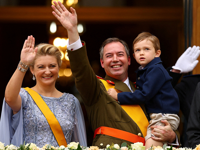 Storhertug Guillaume og Storhertuginne Stéphanie hilser fra slottsbalkongen sammen med sin eldste sønn, Prins Charles. Foto: Yves Herman / AFP / NTB
