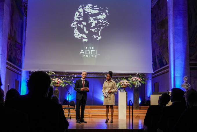 Komiteleder Helge Holden i Abelkomiteen og programleder Haddy Njie under utdelingen av Abelprisen for 2025 til Masaki Kashiwara under en seremoni i Universitetets aula tirsdag. Foto: Ole Berg-Rusten / NTB