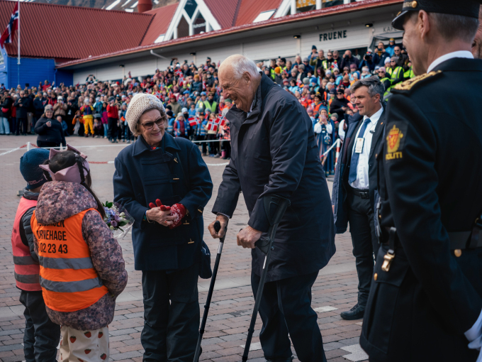 Kong Harald og Dronning Sonja ankommer torget i Longyearbyen. Der venter Tore Salte (6) og Nitchamon Khamhuaiyae (6) med blomster. Foto: Ola Vatn, Det kongelige hoff