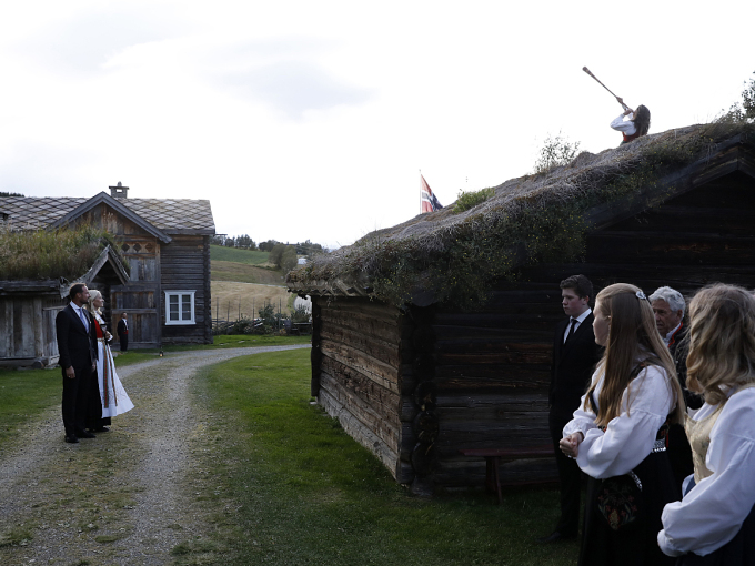 Kronprinsparet høyrer Tone Jorunn Tveito lokke til fest frå taket på ein av bygningane på Gammal-Kleppe. Foto: Tom Hansen, Hansenfoto.no