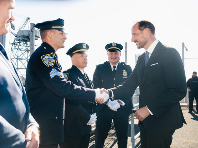 Kronprins Haakon møter representanter for foreningen NYPD Vikings på fergekaia i Brooklyn. NYPD Vikings ble grunnlagt i 1958 av løytnant Erling Johansen, sønn av norske innvandrere. NYPD Vikings består av nåværende og pensjonerte politibetjenter med skandinavisk bakgrunn. Foto: Ola Vatn, Det kongelige hoff