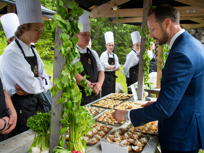 Kronprins Haakon forsyne seg av fingermaten. Foto: Heiko Junge, NTB scanpix